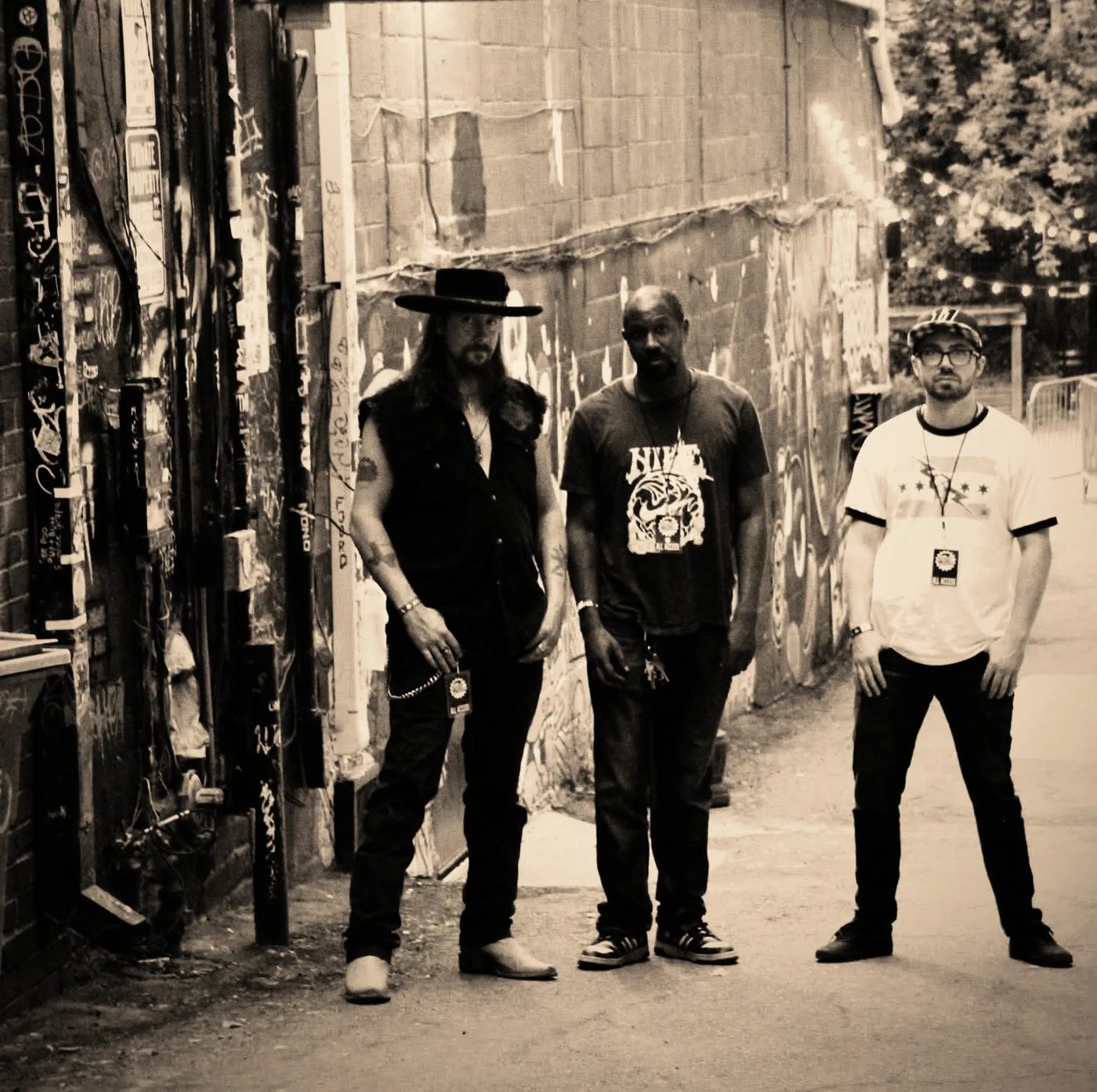 Detroit Trouble's three members standing without instruments in a Detroit alley, the approved hero photograph.