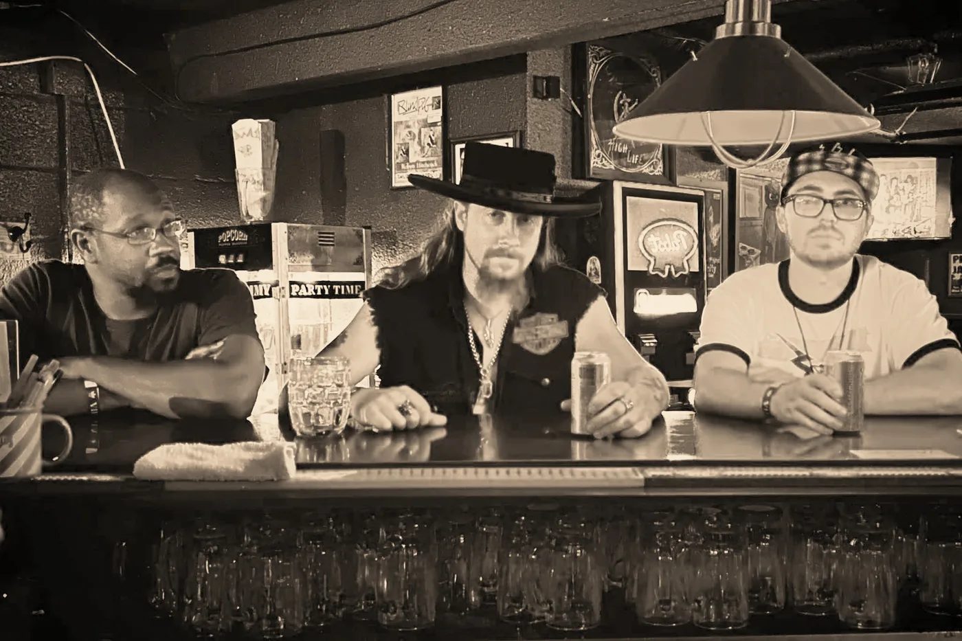 Demarcus Sumter, Kidd Lightning and Alex Blackburn seated at a bar, the trio portrait used in the EPK's Band section.