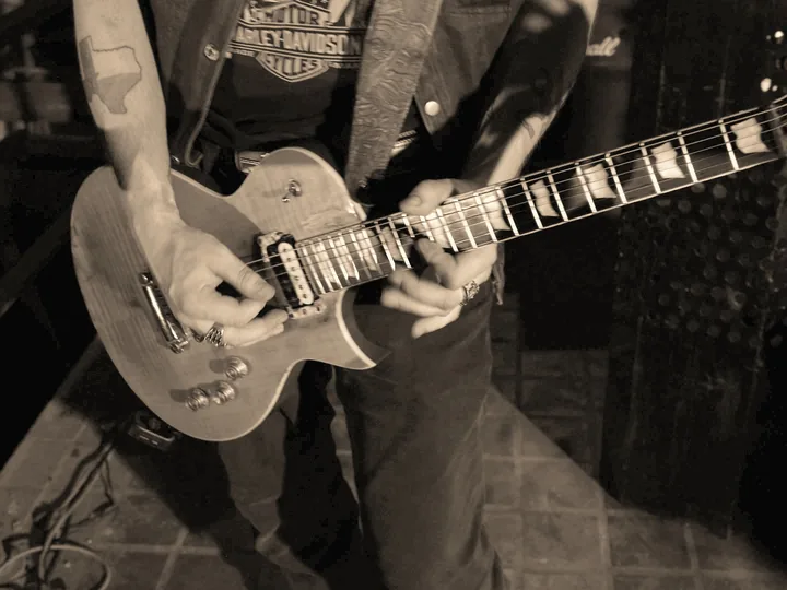 Close-up of Kidd Lightning playing guitar in the Here Tonight video.